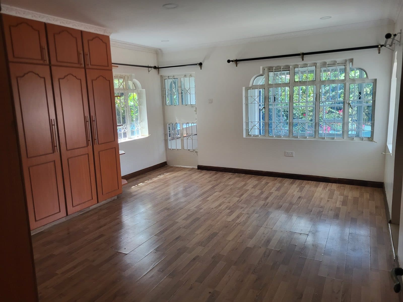 A bedroom with a built in wardrobe and arched windows