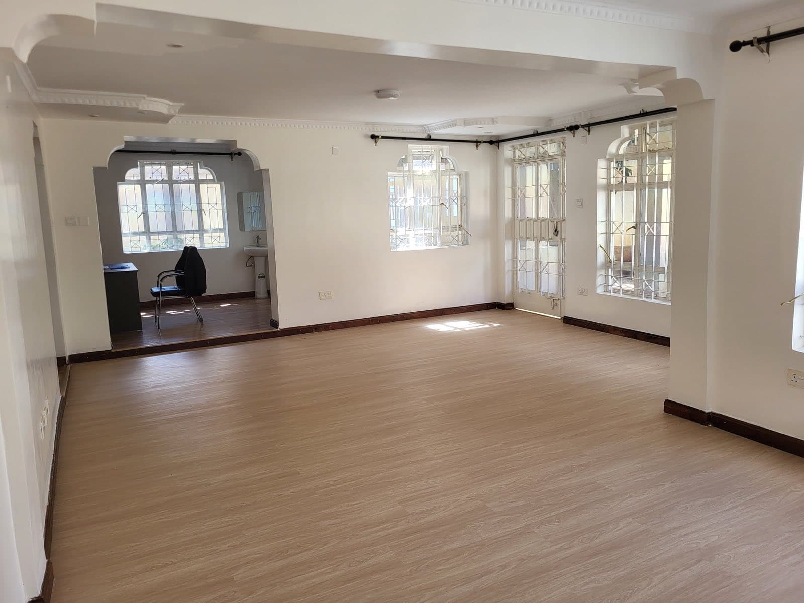 A bright, empty living room with wooden floors